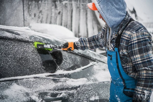 白种人用软刷工具从他的现代汽车上移除了新雪 — 图库照片