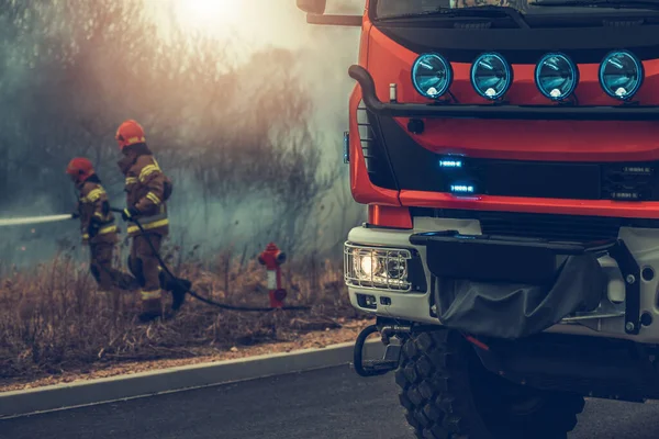 Modern European Fire Truck Two Firefighters Fighting Grass Wildfire Background — Stock Photo, Image