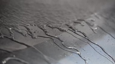 Su, yıkanırken bir arabanın üzerine akıyor.