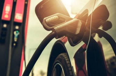 Modern elektrikli araba şarj sırasında yüksek voltajlı EV istasyonuna bağlandı. Otomotiv Endüstrisi TemasıName.