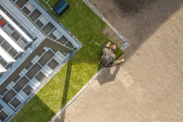 現代のアルミニウム ガゼボ航空写真の隣の裏庭に新しい天然芝のターフを設置する白人造園労働者 造園産業のテーマ — ストック写真