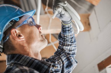 Profesyonel Elektrikçi Yakından Bak. Kabloyu inceleyen Kafkas Elektrik İşçisi. Endüstriyel Tema.