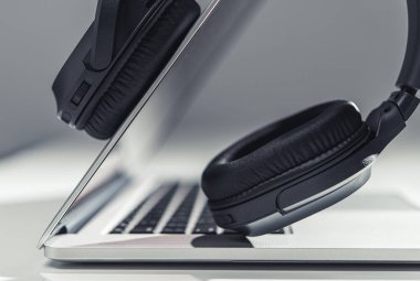 Modern Laptop Bilgisayar ve Profesyonel Kablosuz Kulaklıklar Dijital Ses Karıştırma Konsepti. Ses dosyalarıyla çalışıyorum. Müzik Endüstrisi.