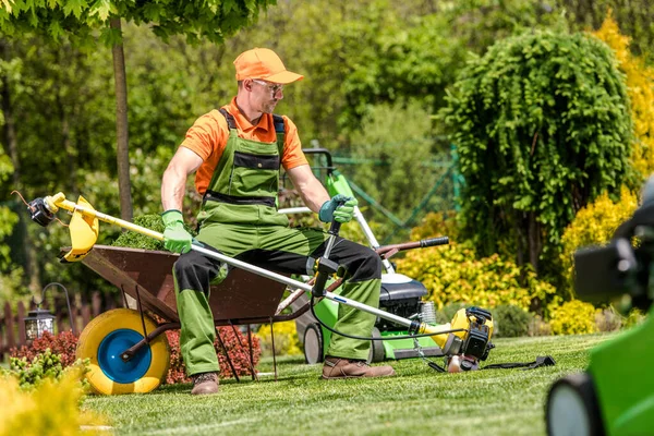 Caucasian Landscape Gardener Resting While Mowing Lawn Sitting Wheelbarrow Holding — Stock Photo, Image