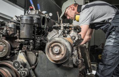 Ağır Görev Koçu Dizel Motor 'u Yeniden İnşa Etmek. Profesyonel Kafkasyalı Tamirci Yakından Bakıyor. Otomotiv Endüstrisi.