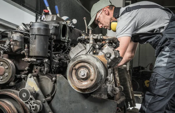 Rebuilding Heavy Duty Coach Bus Diesel Engine. Professional Caucasian Mechanic Taking Closer Look. Automotive Industry.