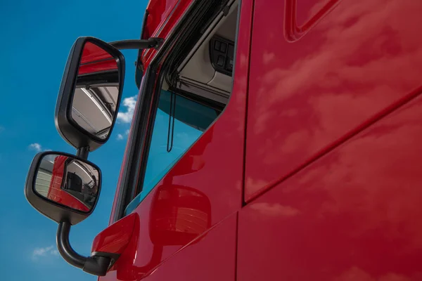 Red Modern Euro Semi Truck Tractor and the Clear Blue Sky. Heavy Transportation Industry.