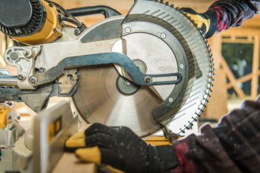 İnşaat işçisi ahşap kiriş kesiyor Büyük dairesel testere kullanarak Yakın çekim