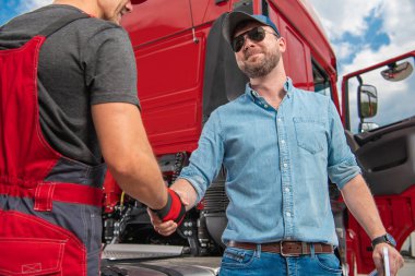 Heavy Duty Transportation Theme. Happy and Smiling Caucasian Truck Driver Shaking His Mechanics Hand.