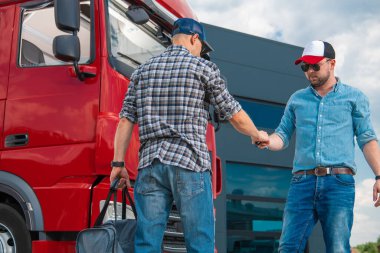 Meeting of Two Lorry Drivers In a Parking Lot to Swap Shifts. Man Passing the Keys of Red Semi Truck to His Colleague to Continue the Delivery. Safety Rules For Heavy Duty Transportation.