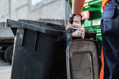 Garbage Truck Worker Moving Clean Black Trash Can Close Up. Waste Management Theme.