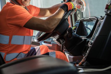 Heavy Duty Transportation Theme. Caucasian Semi Truck Driver Inside Vehicle Cabin Keeping His Hands on a Steering Wheel.