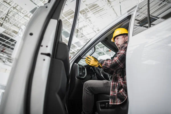 Caucasian Building Supervisor at His 30s Getting Off the Van at the Construction Site Inside the Large Hall Wearing the Safety Helmet. Ready and Determined to Check the Quality of the Work Done.