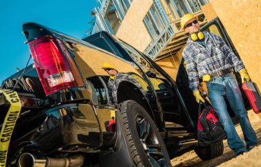 Kararlı Kafkasyalı Müteahhit, Alet Çantası ve Alet Çantası Ellerinde Getirildikten Sonra Hemen İşe Gidiyor. Siyah Kamyonet ve Arkaplanda İkametgah İnşaat Alanı.