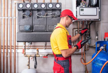 Profesyonel Isıtma Mühendisi Düzenli Gaz Isıtma Sistemi Performans ve Güvenlik Kontrolü yapıyor. Konut Binası Sıcaklık Kurulumu Bakımı.