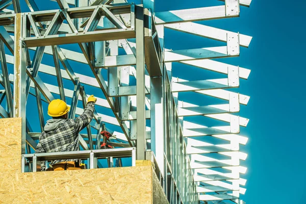 Profesyonel Müteahhit İnşaat Altında Binanın Zirvesinde Çelik Çelik Çerçeve Yapısını Parmakla Gösteriyor. İlerleme Temasında İnşaat Alanı Çalışması.