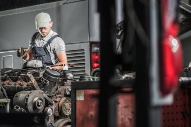 Kafkas Orta Çağ Tamircisi elinde bir tornavidayla Büyük Araba Tamirhanesinde Motor Bakımı ve Tamircisi. Araç Bakım TemasıName.