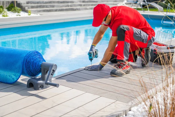 Professional Swimming Pools Worker Finishing Composite Outdoor Pool Deck Installation. SPA Industry Theme.