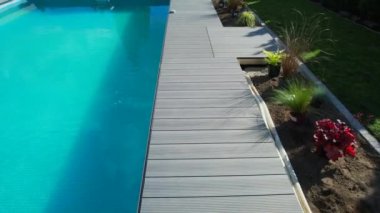 Poolside New Natural Grass Turfs Installation Performed by Professional Landscaper. Residential Swimming Pool Surroundings Design.