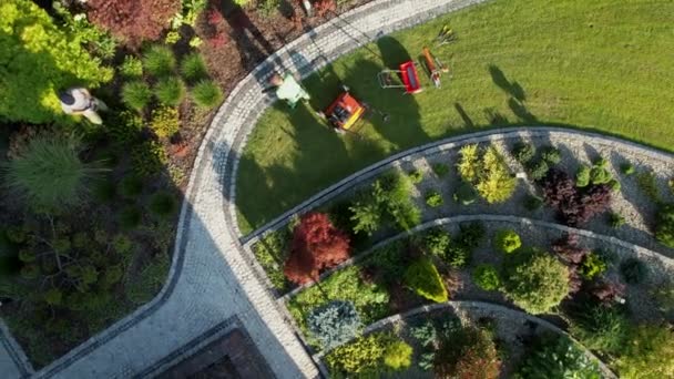 ガーデンパスからの汚れや葉を吹く庭師空中ビュー — ストック動画