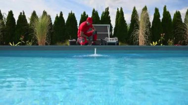 40 'lı yaşlarda profesyonel beyaz yüzme havuzu teknisyeni mevsimsel bakım yapıyor. Açık Bahçe Havuzu.