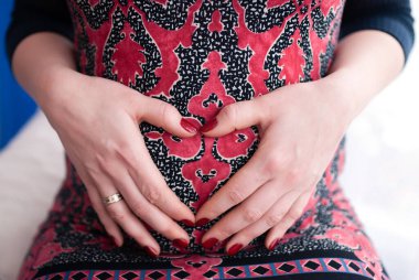 Çift el yapmak kalp simgesi hamile karnına