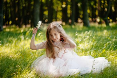 Bahçede saçlarını tarayan bir kız çocuğu. Kiz basina seçici odak