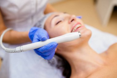 yakın çekim top görünümü yan görünümü kafasındaki bir lazer cilt sağlıklı güzellik spa salonda muamele Kapalı gözlerle bir masanın üzerinde yatan bir havlu ile genç bir kadın portresi