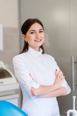 Üniformalı genç bir dişçi ofiste vakit geçirir.