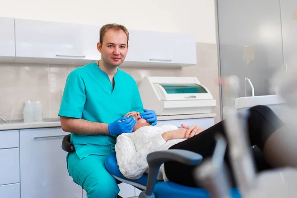 Dentysta Masce Okularach Leczący Pacjentkę Blondynkę Trzymający Narzędzia Dentystyczne Noszący — Zdjęcie stockowe