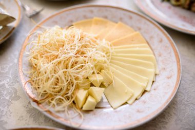 Bir tabak dilimlenmiş peynirle.