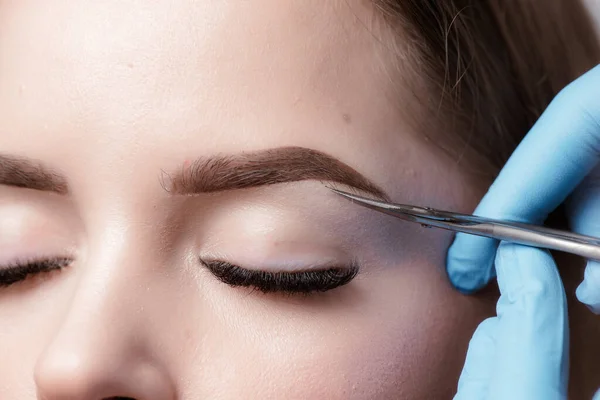 永久的なメイクの眉毛 美容室でのマイクロブロイディング眉毛のワークフロー 女性の眉毛に特別な永久的なメイクを適用する美容師 — ストック写真