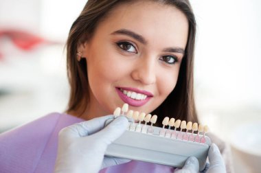Kontrol ve genç kadının diş rengini seçerek diş hekimi