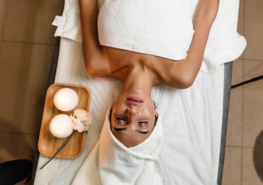 masaj masasında yatan kapalı gözleri ile kadının başının yakın ellerini koyarak şifacı kırpılmış görünümü