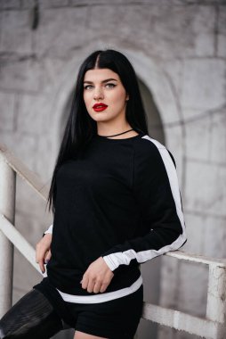 Biyonik bacak ayakta ve beton duvarı açık gülümseyen spor giyim ile atletik engelli kız fotoğrafı