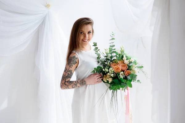 白いドレスと花の花束で美しい妊婦 — ストック写真