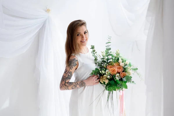 白いドレスと花の花束で美しい妊婦 — ストック写真