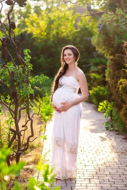 gebelik, sevgi, insanlar ve beklenti kavramı - yeşil doğal arka plan üzerinde mutlu hamile kadın yapma kalp jest