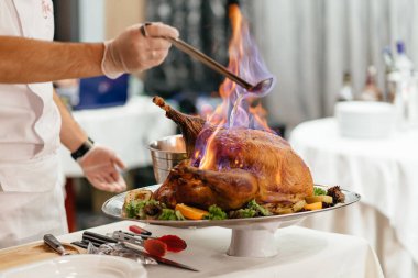 Restoranda sebze tabağında ateşte pişmiş hindi eti. Şef, yanan eti olan misafirler için bir gösteri düzenliyor. Güzel bir sunumu olan bir restoran yemeği. Misafirler için lezzetli et yemeği.