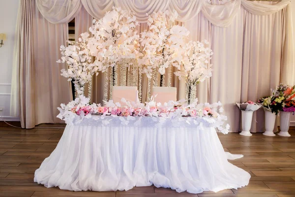 Kurumuş çiçeklerle süslü bir masa. Kaliteli altın çatal, bıçak, mumlar, ahşap masada tozlu mavi peçeteler. Kış düğün dekorasyonu