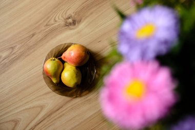 Armutlar ve çiçekler masada.