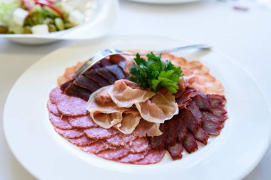 Bir tabak sosis ve et.