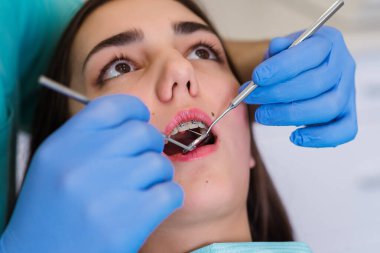 Klinikte diş beyazlatma için dişçiye giden bir kadının yakın plan portresi..