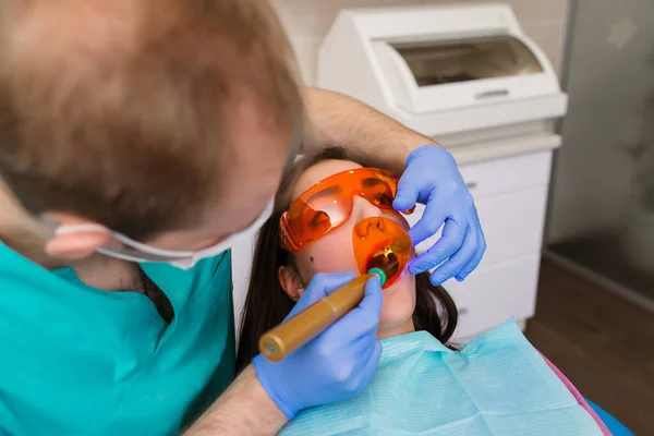 Жінка Пацієнтка Стоматологічних Окулярах Лікує Зуби Стоматолога Ультрафіолетовим Світлом Зубні — стокове фото