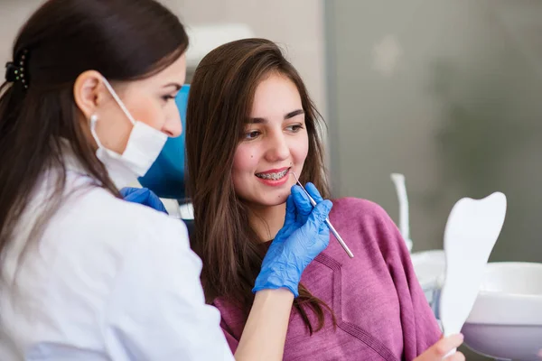Uśmiechnięta Młoda Dziewczyna Patrzy Lustro Aby Ocenić Pracę Dentysty Cieszyć — Zdjęcie stockowe