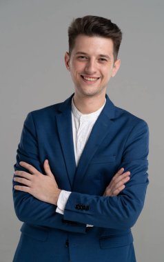 Gri arka planda soyutlanmış yakışıklı, çekici, gülümseyen iş adamı.