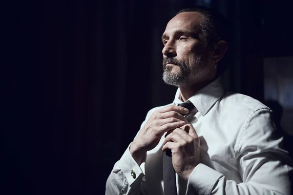 Man Puts Black Tie White Shirt Black Studio — Stockfoto