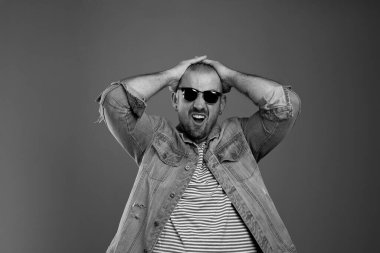 depresif bir adam, günlük kıyafetler ve güneş gözlüğü takmış ellerini başının üstünde tutarken çaresizliğini ifade ediyor. Stresli erkek duyguları