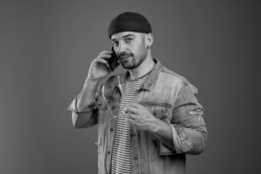 Hoş sohbetti. Pozitif trend adamı göğsünün yanında gözlük tutarken sana bakıyor ve cep telefonundan konuşuyor.