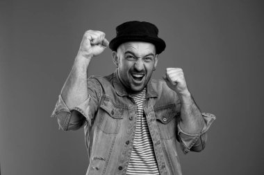 Bağıran yakışıklı adam ellerini yumruk halinde tutarken zafer duyguları yaşıyor.